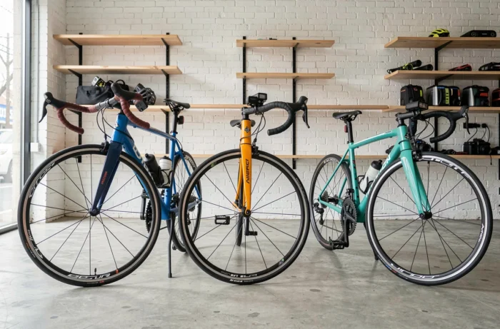 Comparatif de trois vélos de route côte à côte dans un magasin de cycles au sol en béton poli